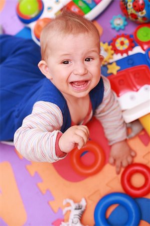 sibling sad - Crying baby with lot of toys Stock Photo - Budget Royalty-Free & Subscription, Code: 400-04629950