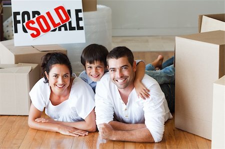 family with sold sign - Happy family lying on the floor after buying new house with boxes Stock Photo - Budget Royalty-Free & Subscription, Code: 400-04621580