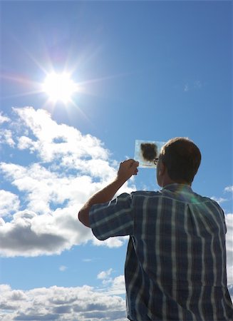 man looks for solar eclipse through smoked glass Photographie de stock - Aubaine LD & Abonnement, Code: 400-04622095