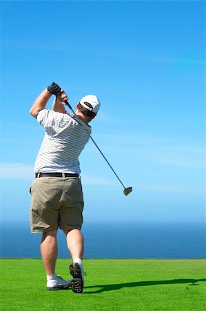 simsearch:400-05038623,k - Young male golfer hitting the ball from the tee box next to the ocean on a beautiful summer day Stock Photo - Budget Royalty-Free & Subscription, Code: 400-04622368