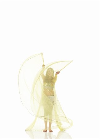 Young Caucasian belly dancing girl in beautiful decorated clothes on white background and reflective floor. Not isolated Foto de stock - Super Valor sin royalties y Suscripción, Código: 400-04623155