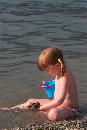 Little girl playing in the sea Fotografie stock - Microstock e Abbonamento, Codice: 400-04623711
