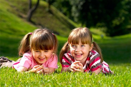 simsearch:400-05352235,k - Two little smiling girls lying on the grass in the park Photographie de stock - Aubaine LD & Abonnement, Code: 400-04623726