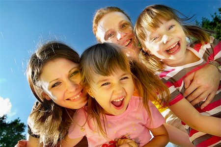 Two mothers with their little daughters smiling and laughing in the park Fotografie stock - Microstock e Abbonamento, Codice: 400-04623729