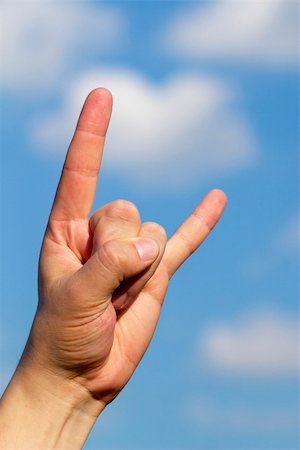 Heavy Metal Rock gesture with a sky and clouds as a background Fotografie stock - Microstock e Abbonamento, Codice: 400-04623734