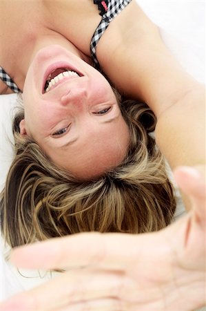 Woman in bed smiling with her hand held up to the camera Stock Photo - Budget Royalty-Free & Subscription, Code: 400-04623923