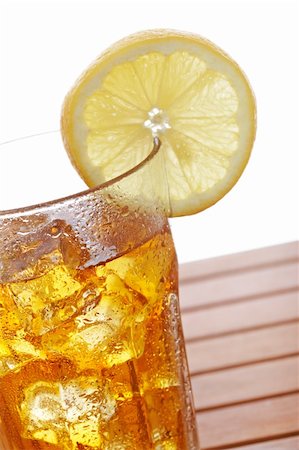 simsearch:400-06877048,k - A glass of ice tea with lemon slice on wooden background. Shallow depth of field Foto de stock - Royalty-Free Super Valor e Assinatura, Número: 400-04623956