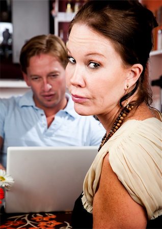 Handsome man using laptop ignoring his pretty date in coffee house Stock Photo - Budget Royalty-Free & Subscription, Code: 400-04634036