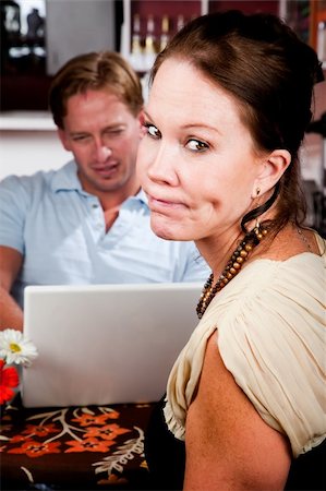 Handsome man using laptop ignoring his pretty date in coffee house Stock Photo - Budget Royalty-Free & Subscription, Code: 400-04634037