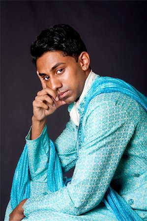 desi guy - Beautiful face of an Indian Hindu young man with earring wearing blue Dhoti. Portrait of handsome Desi male sitting and thinking, isolated. Stock Photo - Budget Royalty-Free & Subscription, Code: 400-04634551