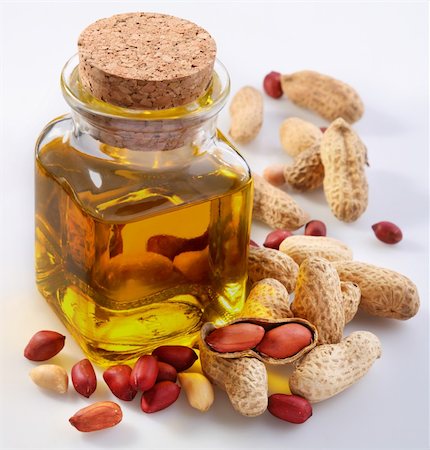 Peanut oil with nuts on a white background Foto de stock - Royalty-Free Super Valor e Assinatura, Número: 400-04635113