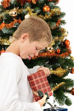 Young boy opening Christmas present near Christmas tree, studio shot Stock Photo - Budget Royalty-Free & Subscription, Code: 400-04635757