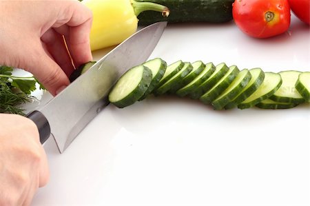 Someone cutting a cucumber, and slice flying isolated on white Stock Photo - Budget Royalty-Free & Subscription, Code: 400-04636514