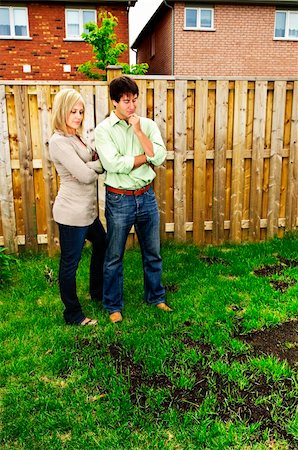 simsearch:400-08074641,k - Young couple worried about growing lawn in backyard of new home Stock Photo - Budget Royalty-Free & Subscription, Code: 400-04636782
