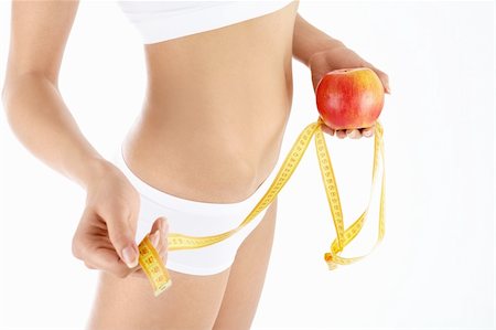 Side view of a harmonous female body, measuring tape and apple in the hands, isolated Foto de stock - Super Valor sin royalties y Suscripción, Código: 400-04637284