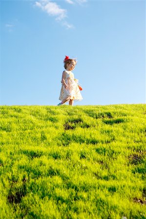 simsearch:400-06768635,k - Little girl on green grass hill over blue sky Foto de stock - Royalty-Free Super Valor e Assinatura, Número: 400-04637387