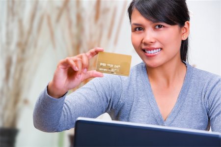 A young Asian woman showing her gold credit card. Stock Photo - Budget Royalty-Free & Subscription, Code: 400-04639193