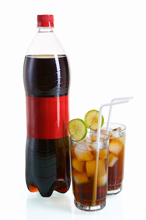 A bottle of cola placed along with two glasses of it with ice ,sliced lime and straw, isolated on white with reflection on glass desk. Stock Photo - Budget Royalty-Free & Subscription, Code: 400-04639271
