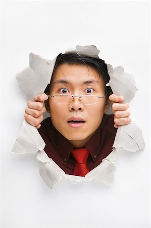 Man with funny expression gazing from hole in wall Stock Photo - Budget Royalty-Free & Subscription, Code: 400-04639576