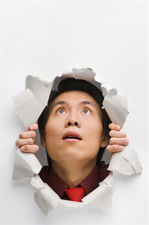 Man looking up surprisingly from hole in wall Stock Photo - Budget Royalty-Free & Subscription, Code: 400-04639580