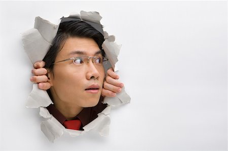 Man looking away to his left side from hole in wall Stock Photo - Budget Royalty-Free & Subscription, Code: 400-04639582