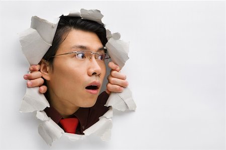 Man from hole in wall surprisingly looking away to his left side Stock Photo - Budget Royalty-Free & Subscription, Code: 400-04639583