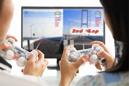 A couple playing racing game. The image and design on screen are mine. Photographie de stock - Aubaine LD & Abonnement, Code: 400-04639816