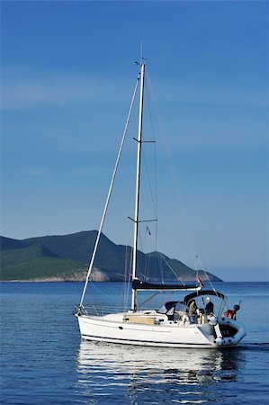 simsearch:851-02963102,k - Sailing yacht with two people approaching a remote Greek island in early morning Stock Photo - Budget Royalty-Free & Subscription, Code: 400-04639841