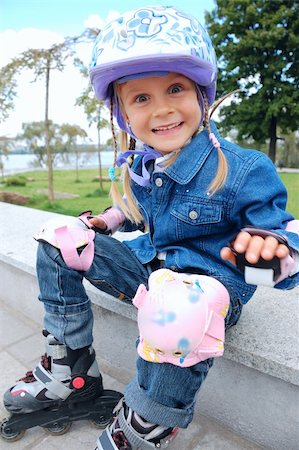 cute happy girl with rollerskates and pretective helmet and pads Foto de stock - Super Valor sin royalties y Suscripción, Código: 400-04631343