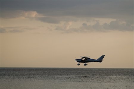 sunset small plane - Low flying small private airplane over sea Stock Photo - Budget Royalty-Free & Subscription, Code: 400-04631722