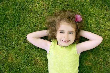 simsearch:400-05248187,k - Beautiful little toddler girl happy lying on the green grass Photographie de stock - Aubaine LD & Abonnement, Code: 400-04631901