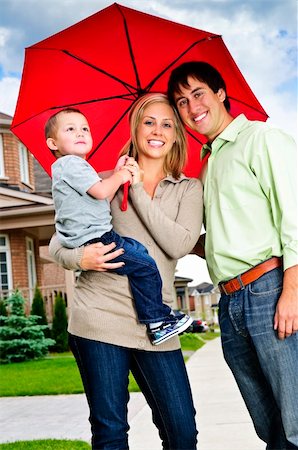 family in a suburban community - Young happy family under umbrella on sidewalk Stock Photo - Budget Royalty-Free & Subscription, Code: 400-04633785