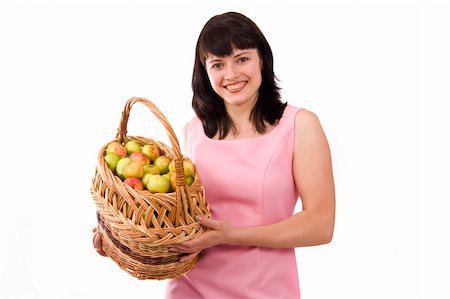 Girl in pink dress is standing and holding a basket full apples on white background. Beautiful woman holding a basket of delicious fresh fruits. Pretty girl with basket of apples. Isolated over white. Stock Photo - Budget Royalty-Free & Subscription, Code: 400-04644851