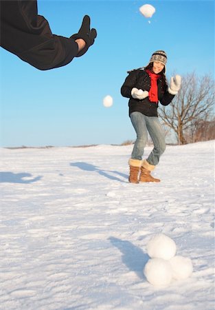 Snowball fight - winter fun. Couple throwing snowballs at each other. Photographie de stock - Aubaine LD & Abonnement, Code: 400-04645042