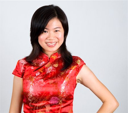 simsearch:400-05132616,k - Oriental woman in red Cheongsam. Cheongsam also known in English as a mandarin gown, is  formal wear for important occasions. Red is lucky color of Chinese, red cheongsam usually wear by during new year day or wedding. Foto de stock - Super Valor sin royalties y Suscripción, Código: 400-04645098