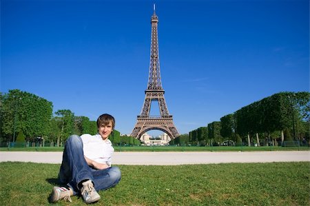 eifel - Young man lying on the Champs de Mars. Eiffel tower in background Fotografie stock - Microstock e Abbonamento, Codice: 400-04648134