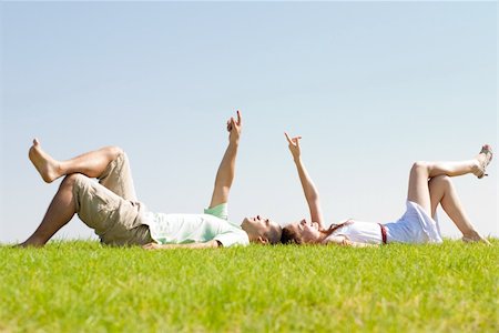 young couple lie down on grass and point to the sky, outdoor at park Stock Photo - Budget Royalty-Free & Subscription, Code: 400-04648259