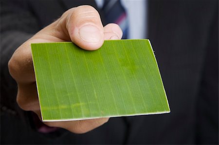simsearch:400-04648812,k - Man giving out a green business card Stock Photo - Budget Royalty-Free & Subscription, Code: 400-04648439