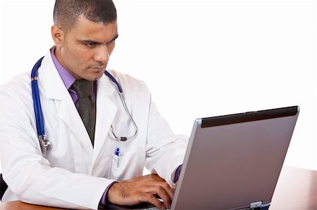 simsearch:400-04178933,k - Doctor is sitting on his desk and typing on laptop. Isolated on white. Stock Photo - Budget Royalty-Free & Subscription, Code: 400-04649547