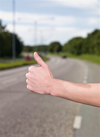 A young man hitchiking on the road Stock Photo - Budget Royalty-Free & Subscription, Code: 400-04640479