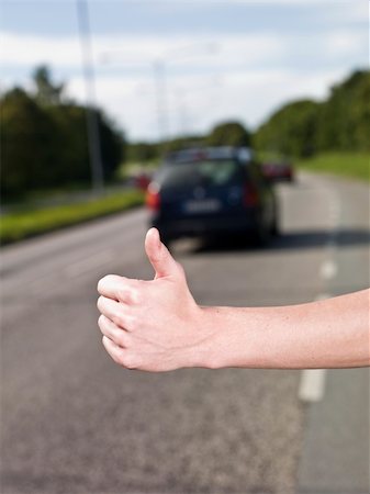 A young man hitchiking on the road Stock Photo - Budget Royalty-Free & Subscription, Code: 400-04640480