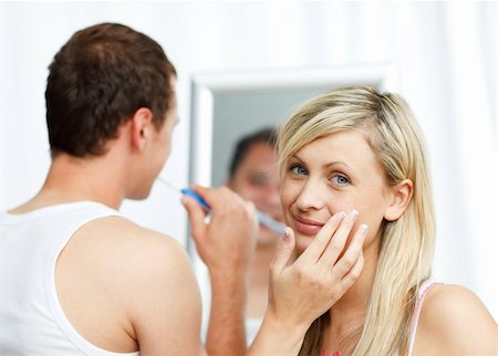 face cream male - Woman putting cream on her face and man cleaning teeth in bathroom Stock Photo - Budget Royalty-Free & Subscription, Code: 400-04640926
