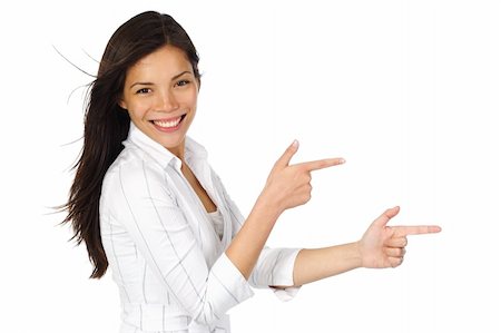 Smiling woman in white pointing at your product while looking at the camera. Isolated on white background. Beautiful mixed asian / caucasian model. Stock Photo - Budget Royalty-Free & Subscription, Code: 400-04642684