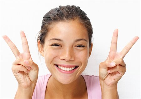 Cute young woman showing the peace / victory hand sign. Photographie de stock - Aubaine LD & Abonnement, Code: 400-04642700