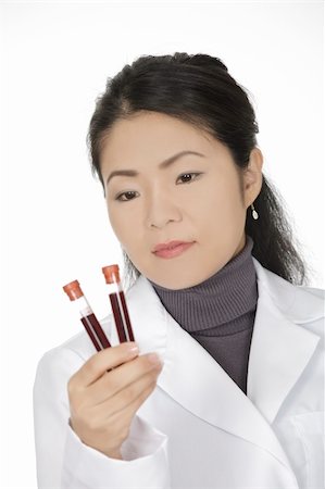 Beautiful Asian laboratory technician examining a tube of blood Stock Photo - Budget Royalty-Free & Subscription, Code: 400-04643224