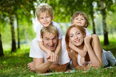 simsearch:400-04654326,k - Happy family with two sons frolic on a lawn Stock Photo - Budget Royalty-Free & Subscription, Code: 400-04654318