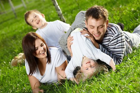 simsearch:400-04195162,k - Young family with two small children frolics on a lawn Foto de stock - Super Valor sin royalties y Suscripción, Código: 400-04654327