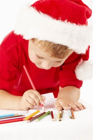 simsearch:400-09222788,k - Little boy in a hat of santa draws on sheet Photographie de stock - Aubaine LD & Abonnement, Code: 400-04654330