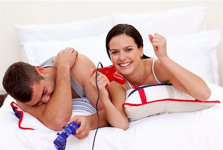 Happy young couple playing videogames in bed Stock Photo - Budget Royalty-Free & Subscription, Code: 400-04654597