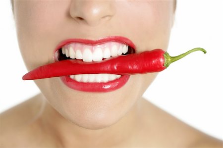 simsearch:400-04575822,k - Beautiful woman teeth eating red hot chili pepper Photographie de stock - Aubaine LD & Abonnement, Code: 400-04654710